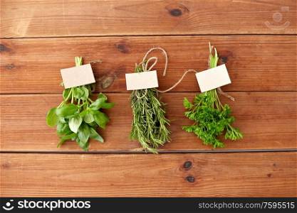 greens, spices or medicinal herbs concept - bunches of parsley, basil and rosemary on wooden boards. greens, spices or medicinal herbs on wooden boards