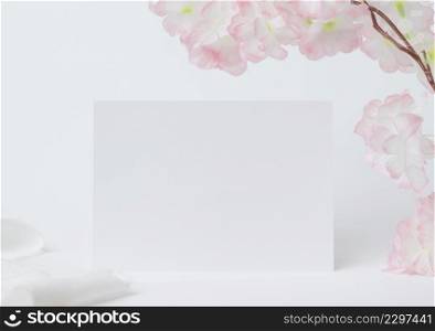 greeting card mock up. decoration with white flower, Front view, Blank paper card on a wood plate and white background