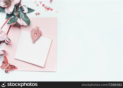 Greeting card mock up with pastel pink heart and flowers on white background , top view, border. Flat lay. Can using to Mothers day, wedding, birthday, Valentines day