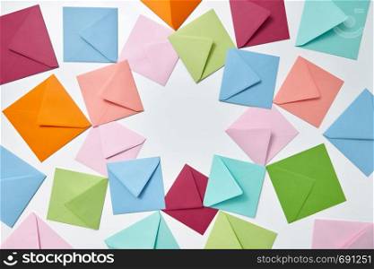 Greeting cards of handcraft multicolored envelopes frame on a light background with copy space.. Colorful frame from empty handmade envelopes on a light background.