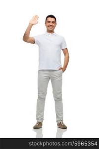 greeting, gesture and people concept - smiling man in blank white t-shirt waving hand