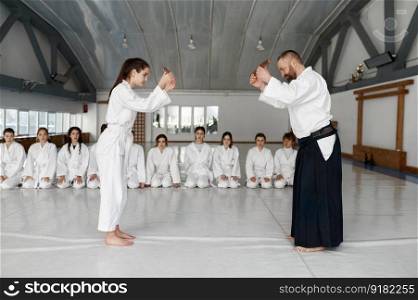Greeting of sensei and student before battle with wooden sword. Group training at professional martial arts school. Greeting of sensei and student before battle with wooden sword
