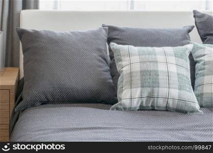 grey and checked green pillows in modern bedroom interior