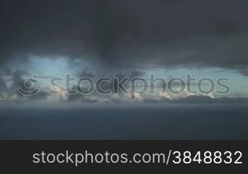 Grey clouds drift over the ocean.