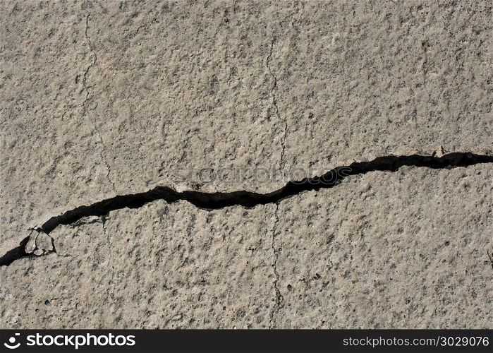 Grey color cracked concrete wall. Grey color deeply cracked concrete wall
