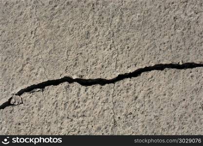 Grey color cracked concrete wall. Grey color deeply cracked concrete wall