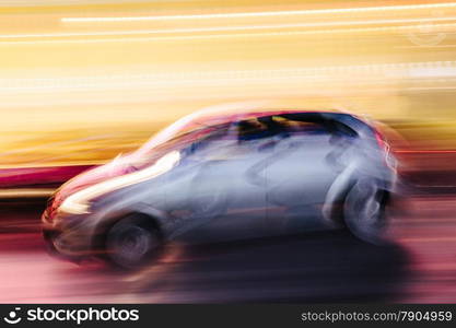 Grey Compact Car in a Blurred City Scene