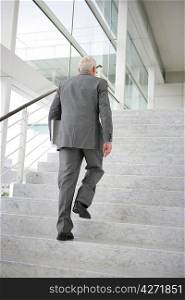 Grey-haired businessman climbing steps