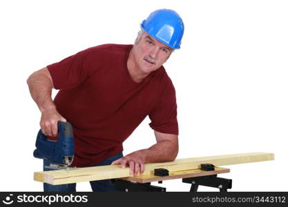 Grey-haired carpenter using electric saw