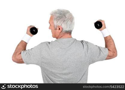 Grey-haired man doing weights
