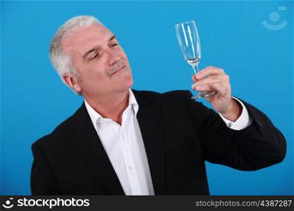 Grey-haired man holding champagne flute
