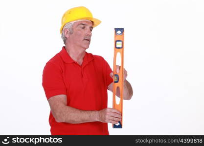 Grey-haired man holding spirit-level