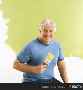 Grey haired man painting