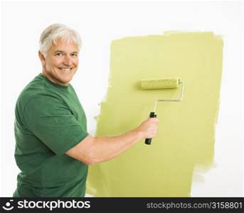 Grey haired man painting