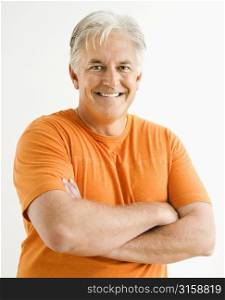 Grey haired man smiling, wearing orange top