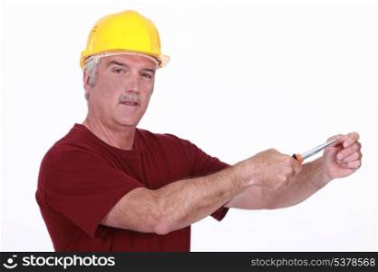 Grey haired man using screw driver