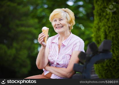 Grey-Haired Woman Relaxing with Ice-Cream on Bench in the Park