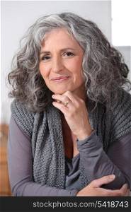 Grey-haired woman touching chin