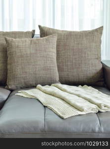 grey leather sofa with texture brown pillows in modern living room