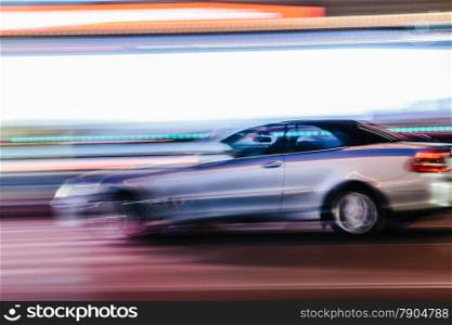 Grey Luxury Car in a Blurred City Scene