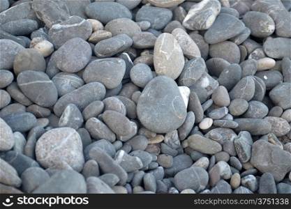 Grey pebbles on the beach at background