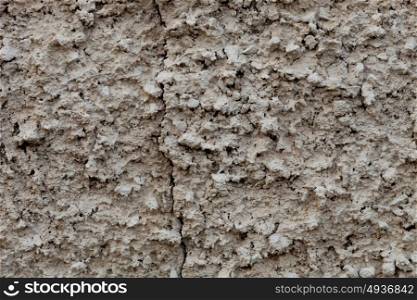 Grey texture of clay in a wall with a crack