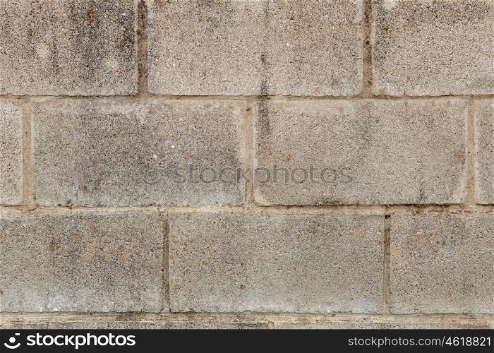 Grey wall of cement blocks damaged by the passage of time