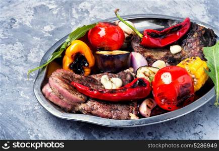 Grill meat and vegetables. Beef barbecue meat, grilled vegetables on a tray