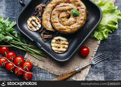 grill pan with delicious spiral grilled sausage vegetable