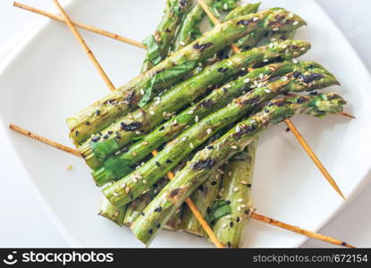 Grilled asparagus rafts with sesame seeds on the plate