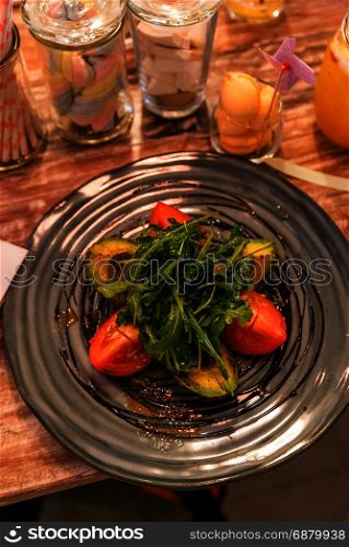Grilled avocado salad with tomato and rocket