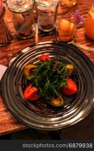 Grilled avocado salad with tomato and rocket