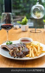Grilled Barbecued Pork Baby Back Ribs grilled sweet corn and fries on dining table with red wine