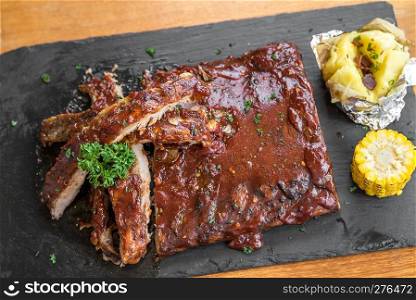 Grilled Barbecued Pork Baby Back Ribs with baked potato and grilled sweet corn