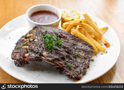 Grilled Barbecued Pork Baby Back Ribs with grilled sweet corn and fries