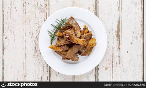 grilled beef fillet steak meat with oregano and rosemary in white plate on white wood texture background, top view, light and airy food photography