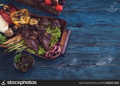 Grilled beef meat. Grilled beef meat with vegetable on a blue wooden background