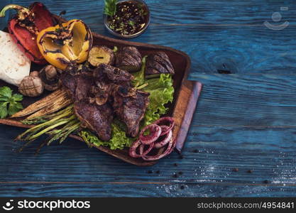 Grilled beef meat. Grilled beef meat with vegetable on a blue wooden background