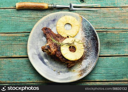 Grilled beef meat with pineapple. Steak with pineapple sauce on plate. Roasted beef in fruit marinade, top view