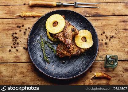 Grilled beef meat with pineapple. Steak with pineapple sauce on plate. Roasted beef in fruit marinade, top view