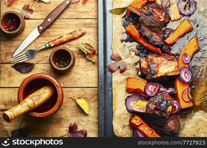Grilled beef ribs with pumpkin.Roasted veal meat with slices of pumpkin. Barbecue beef ribs with pumpkin