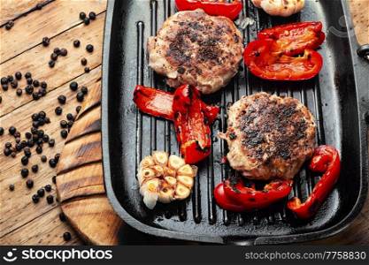 Grilled beef steak, beef and pork with spices. Chopped minced steak or cutlet and juniper spice on grill pan. Beef steak in bacon with minced meat