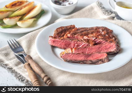 Grilled beef steak garnished with onions