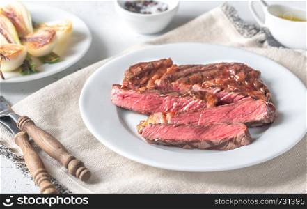 Grilled beef steak garnished with onions