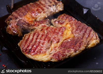 Grilled beef steak. Grilled beef steak in black pan close up