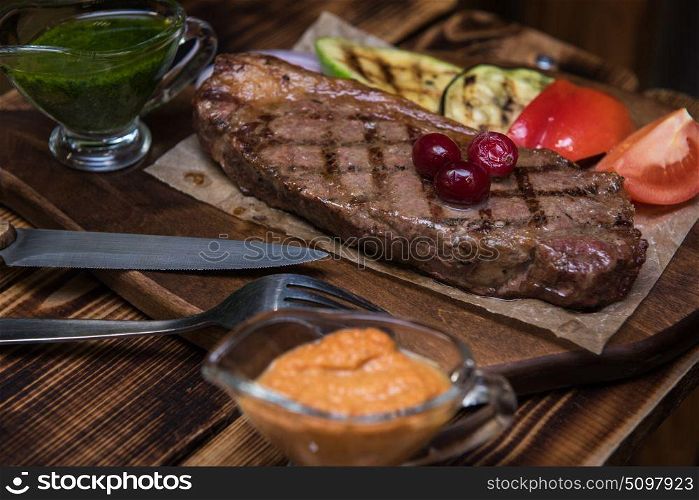 grilled beef steak. grilled beef steak with sauce and vegetables