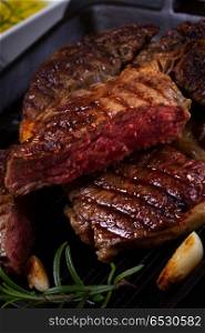 Grilled beef steak. Grilled beef steak with spices close up on dark background