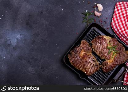 Grilled beef steak. Hot Grilled beef steak on dark background with red and white napkin, copy space on dark background