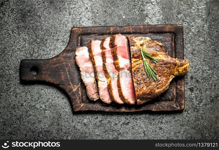 Grilled beef steak on a blackboard with spices. On rustic background.. Grilled beef steak on a blackboard with spices.