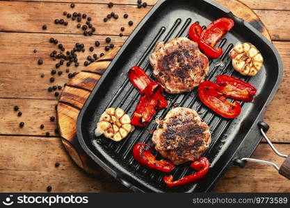 Grilled beef steak or cutlet, beef and pork with spices. Grilled meat, meatball on grill pan. Beef steak in bacon with minced meat.
